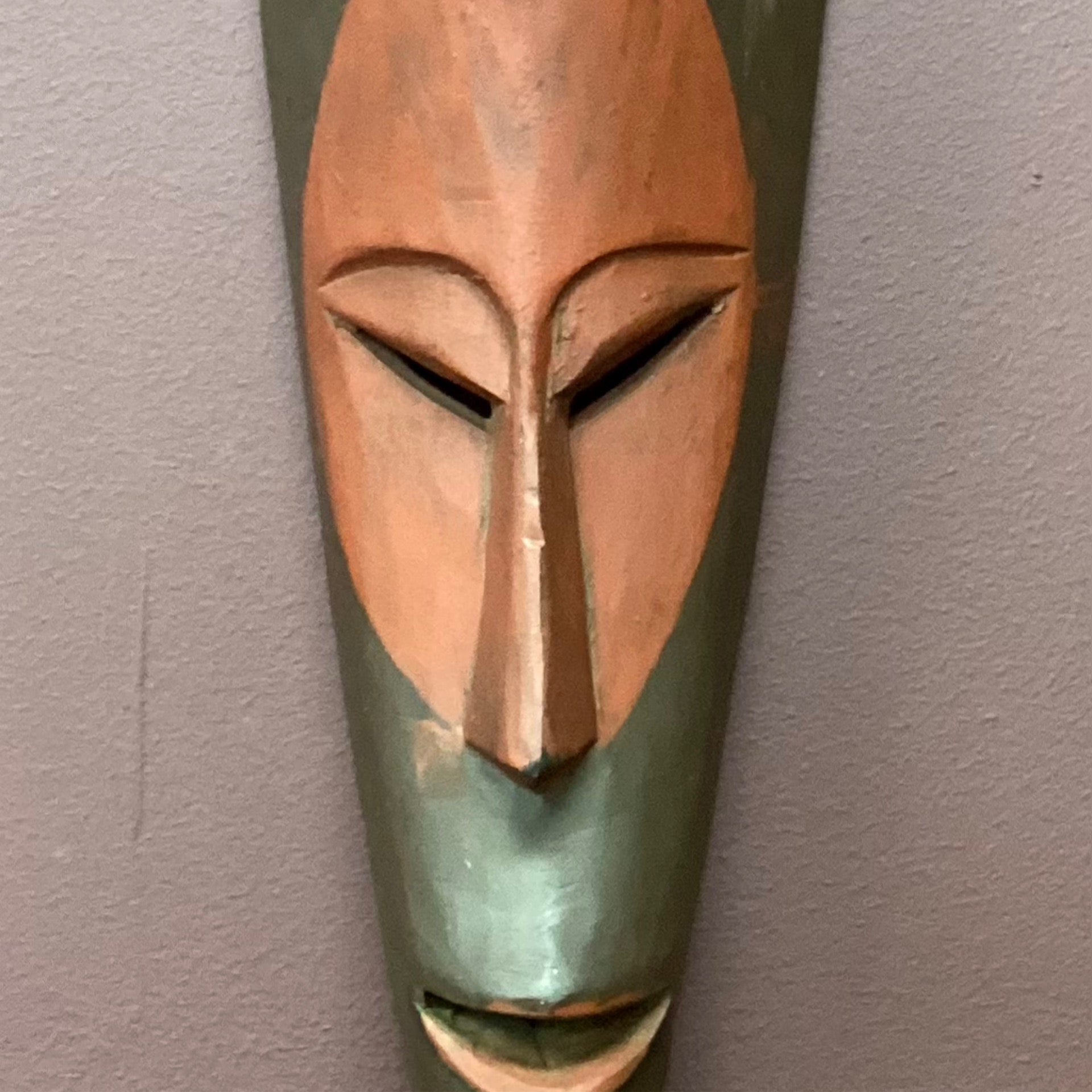 Hand carved African mask with red face (back wall)