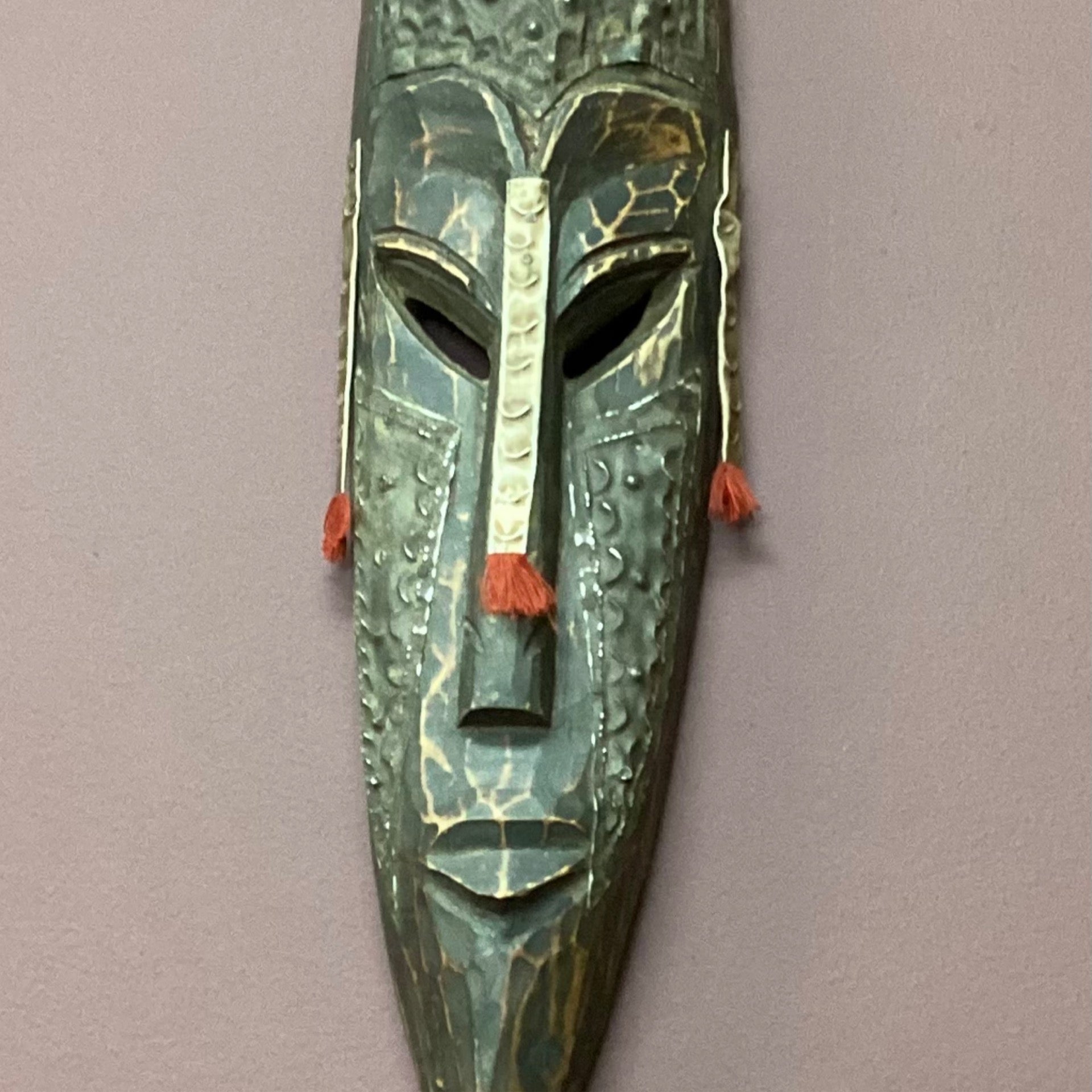 Hand carved African mask with antique finish (back wall)