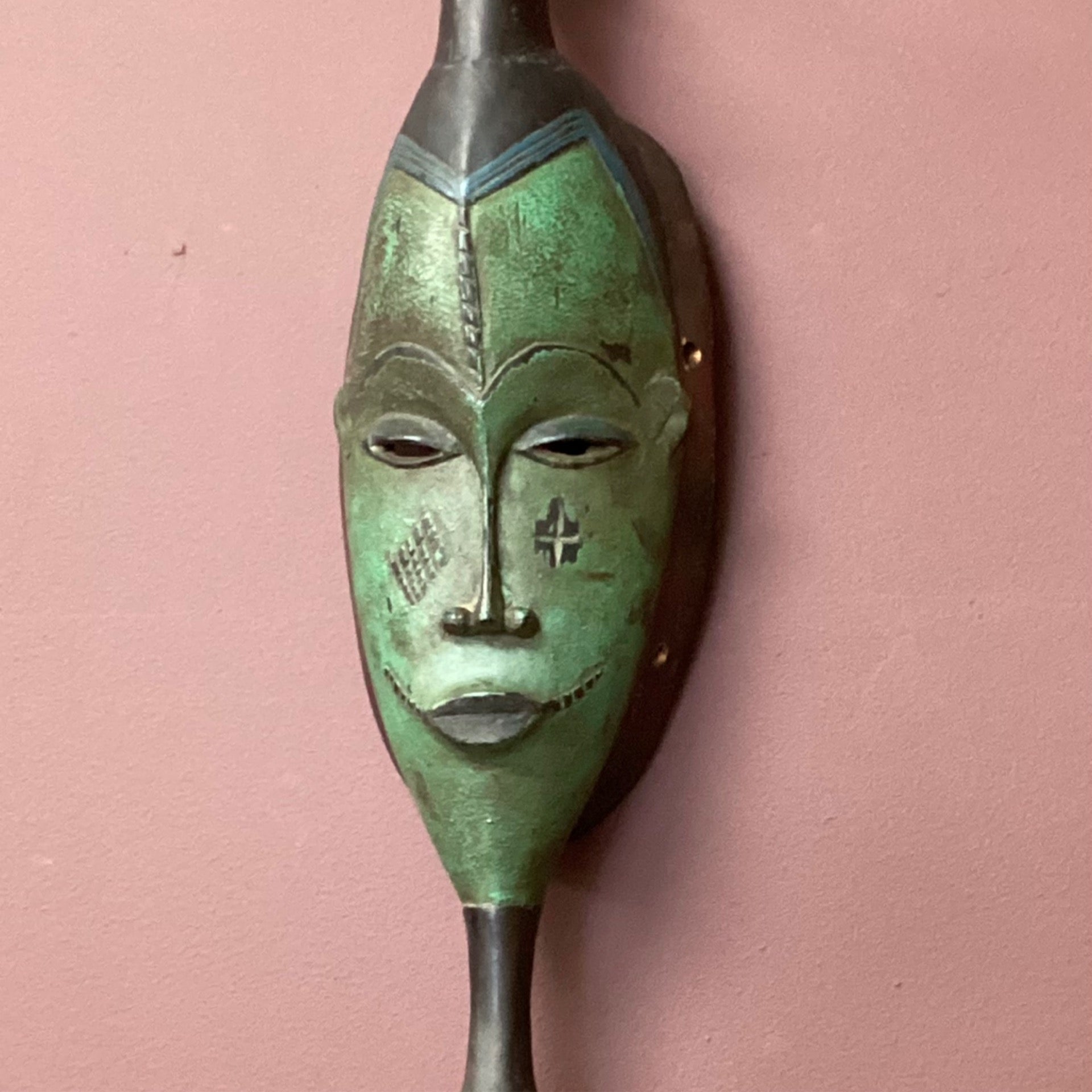Hand carved African mask with green face (back wall)